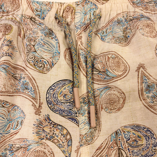 Close-up of a fabric with intricate paisley pattern on a beige background