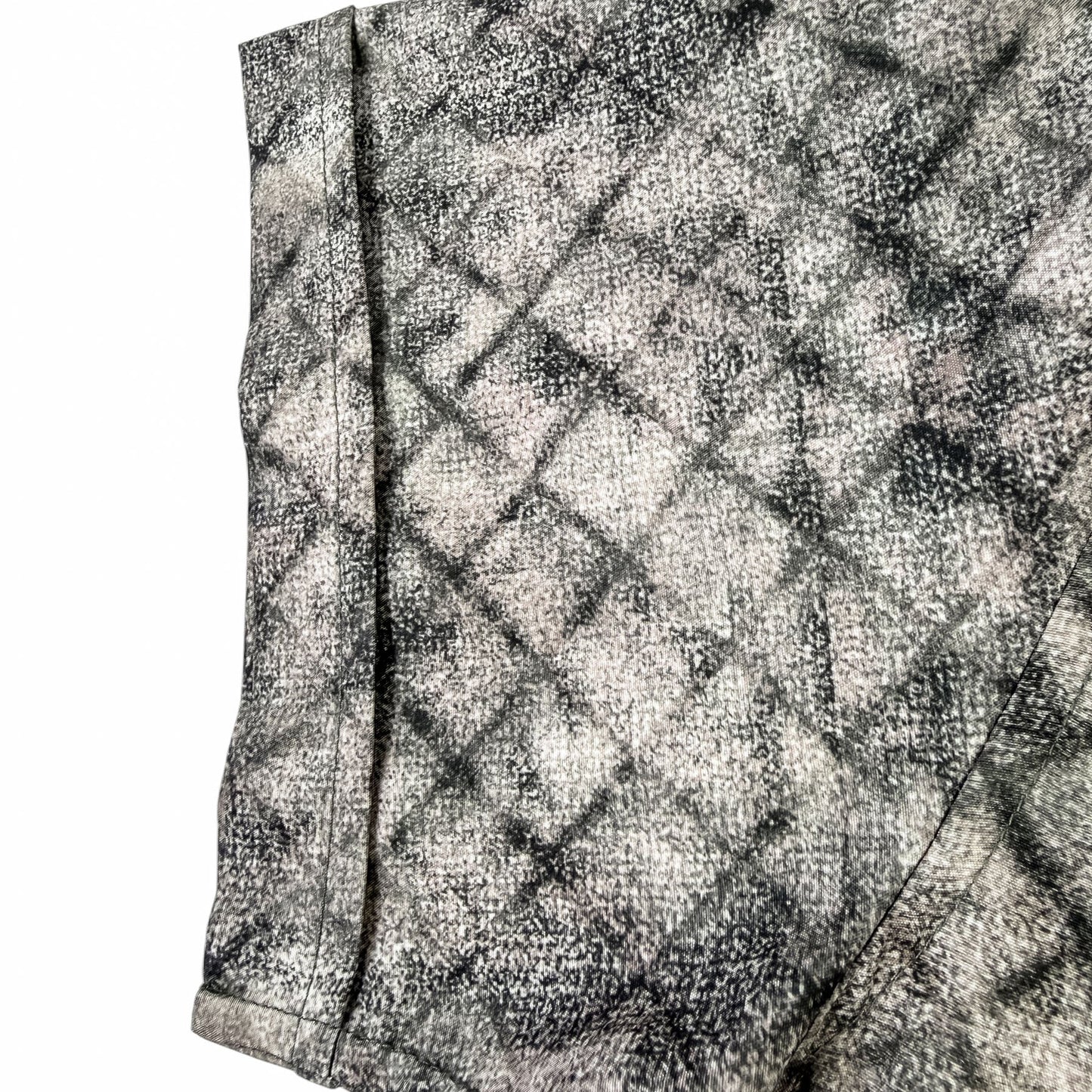 Close-up of a textured shirt sleeve with a geometric pattern on a white background