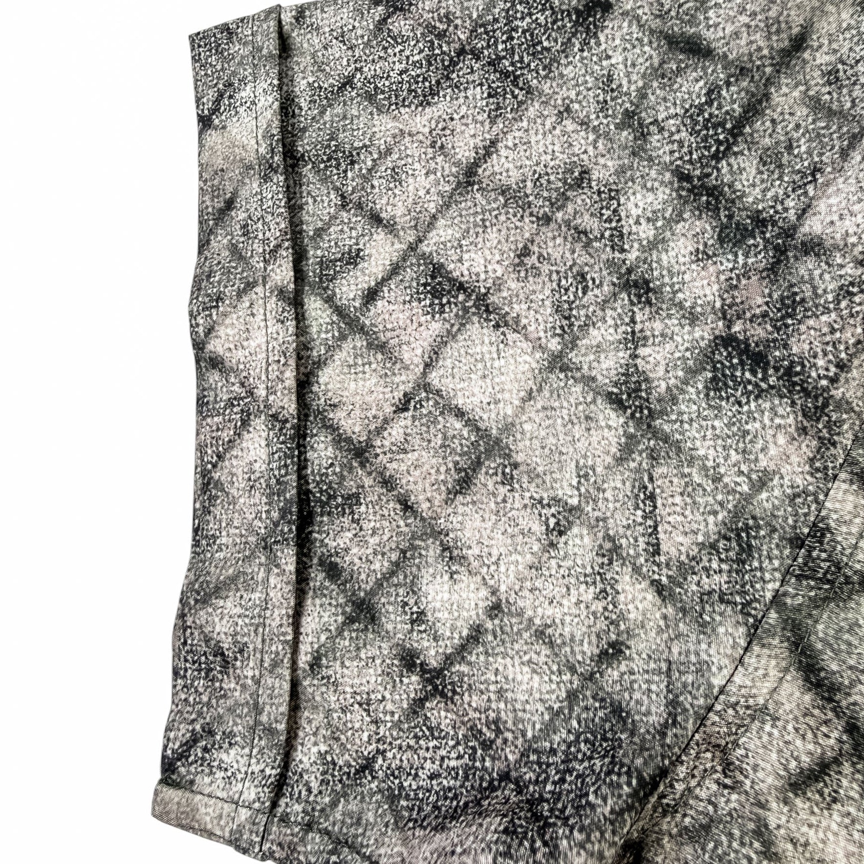 Close-up of a textured shirt sleeve with a geometric pattern on a white background