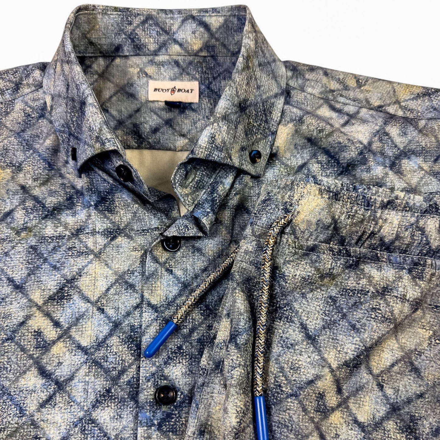 Patterned shirt and shorts with blue buttons on a white background