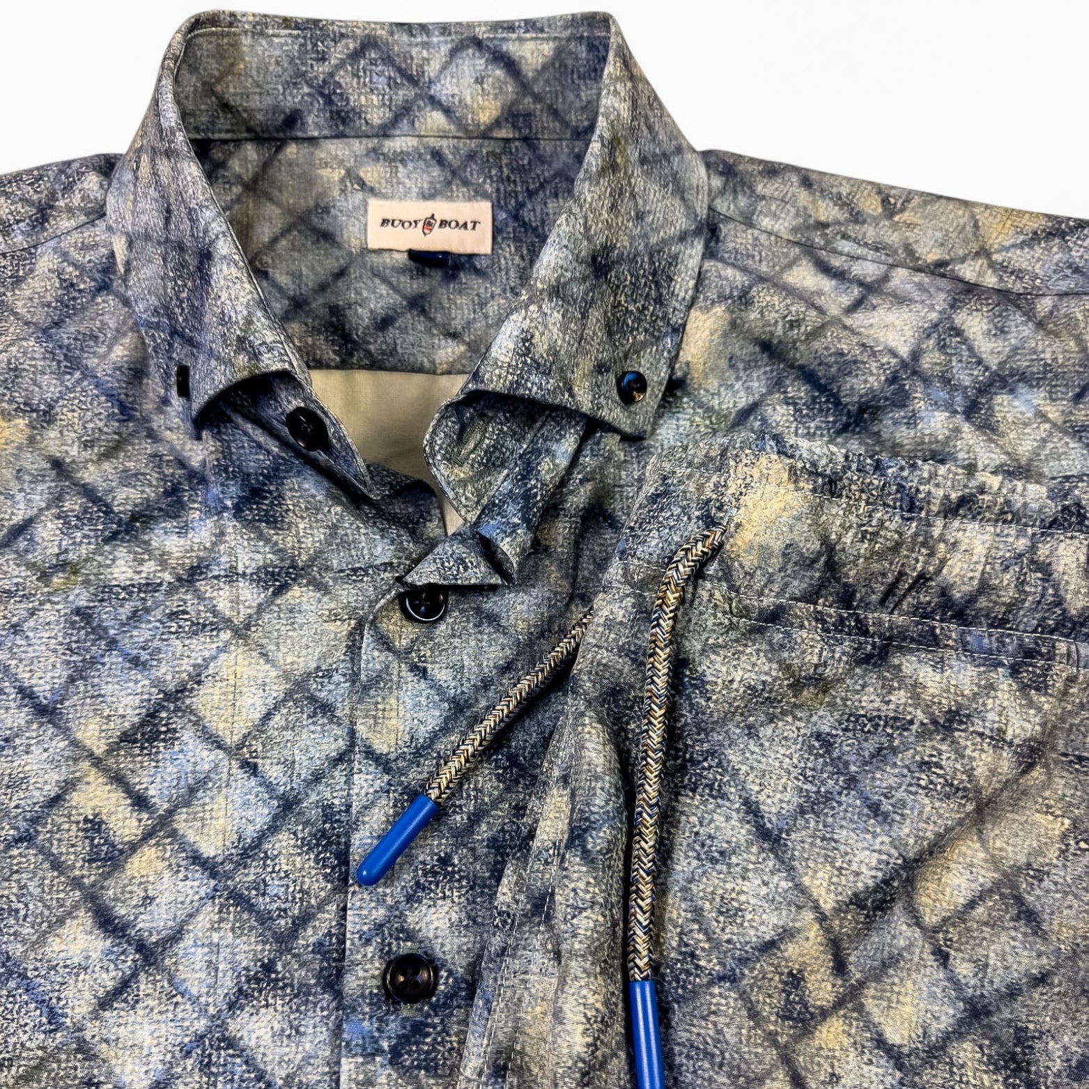 Patterned shirt and shorts with blue buttons on a white background