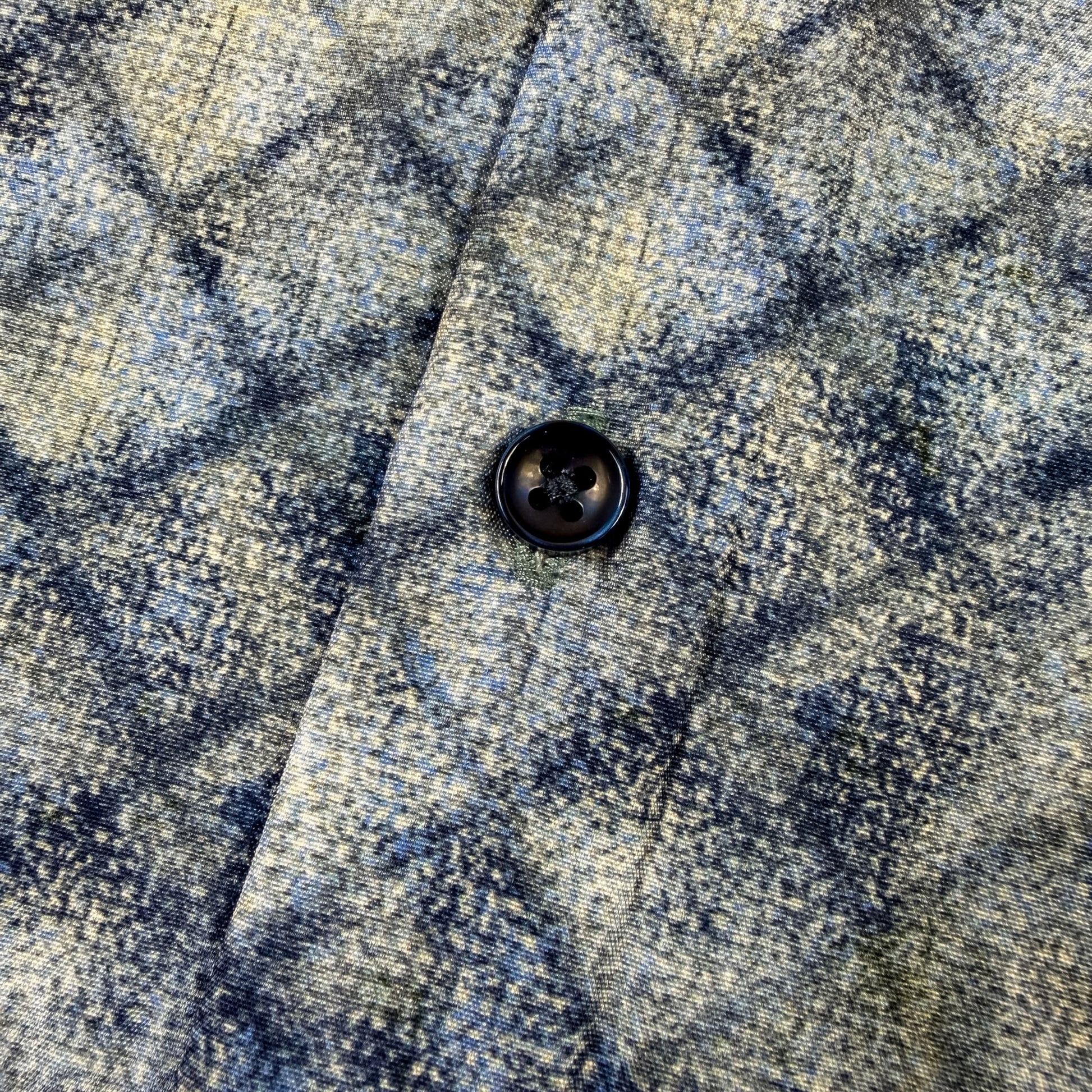 Close-up of blue and gray checkered fabric with a button