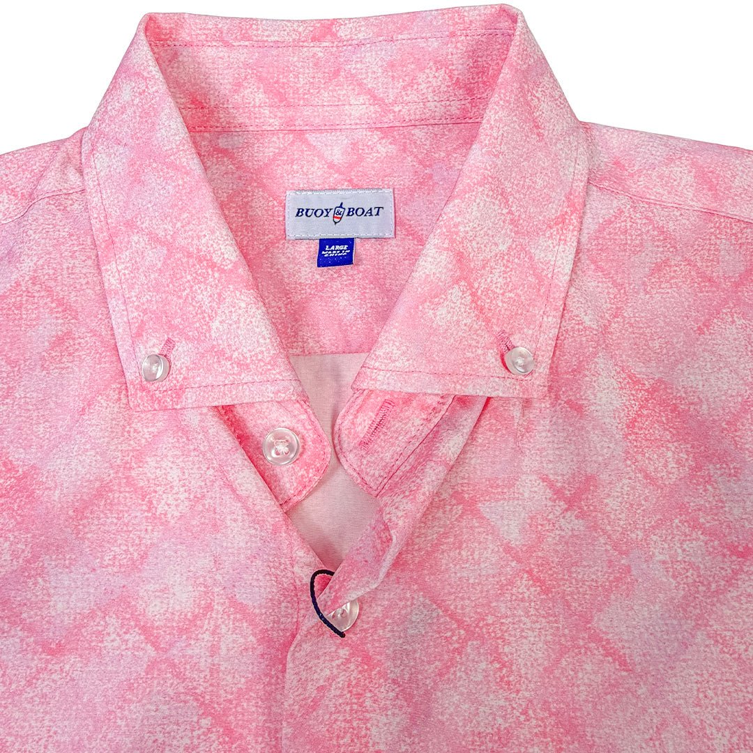 Close-up of a pink patterned shirt with a brand label on a white background