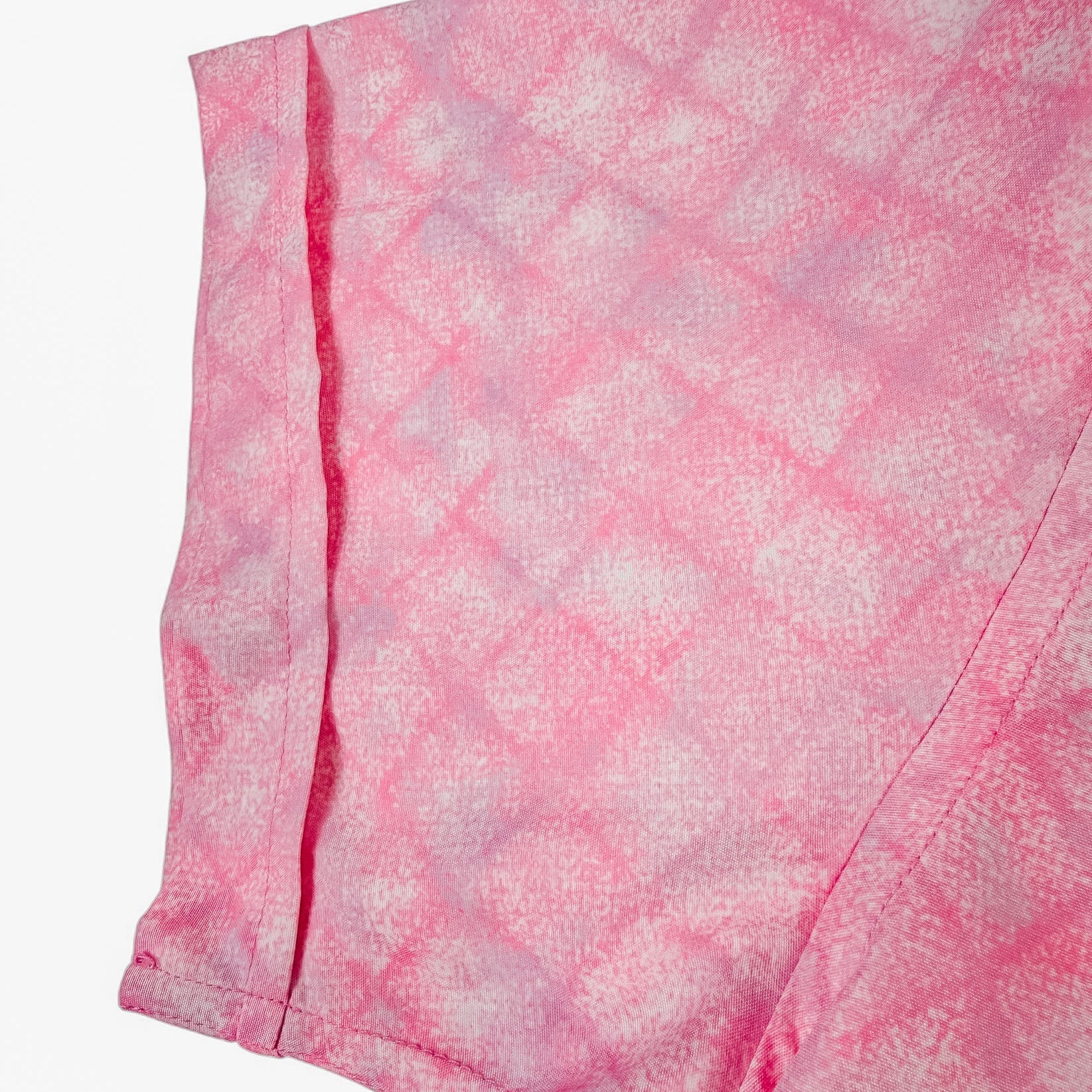 Close-up of pink shirt sleeve with patterned fabric on a white background