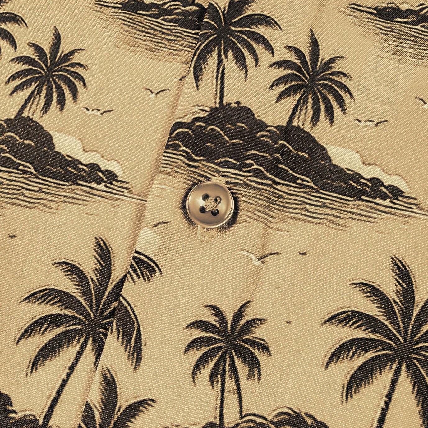 Beige shirt with black palm tree pattern and button detail