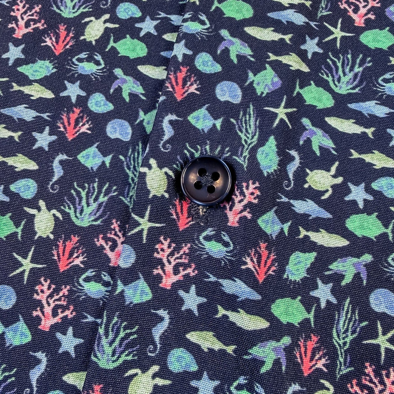 Navy shirt with colorful sea-themed pattern on a white background