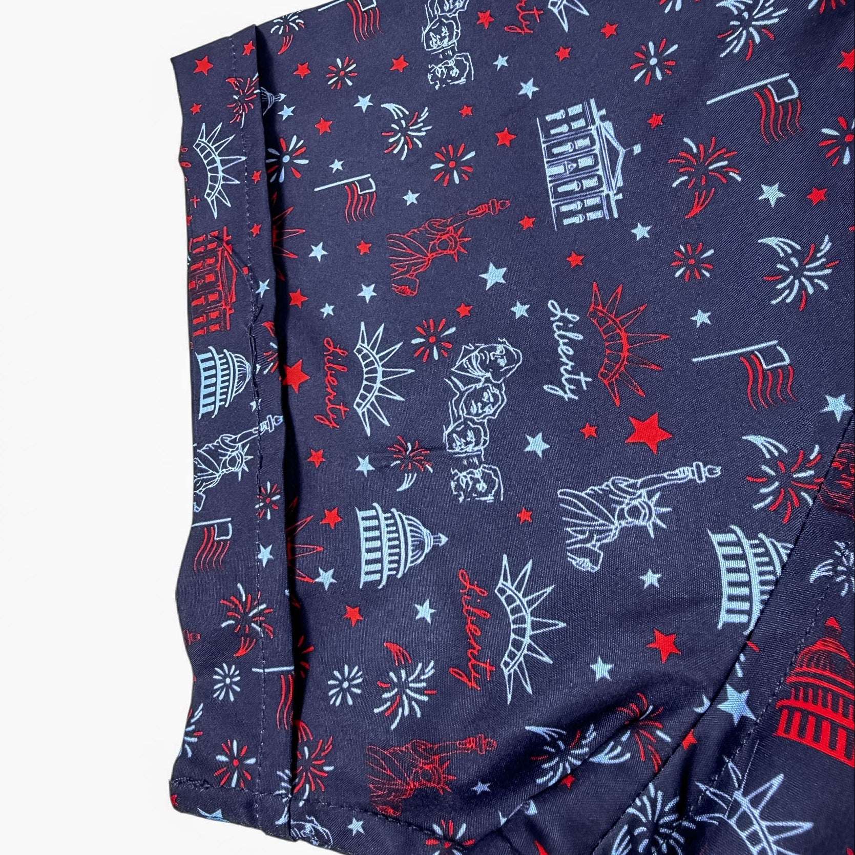 Shirt sleeve with patriotic pattern featuring stars, stripes, and American symbols on a blue background.
