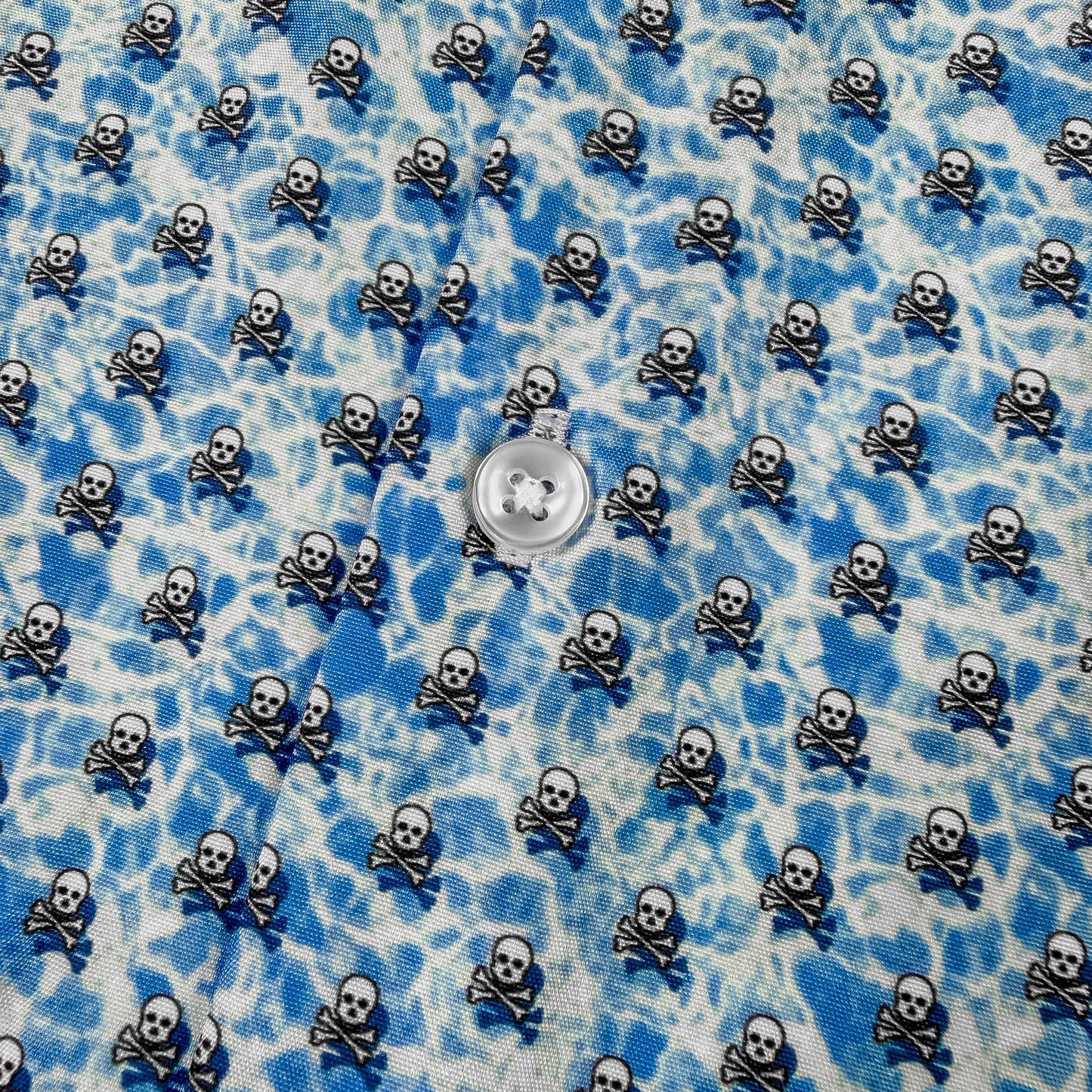 Blue and white patterned fabric with small skull and crossbones design