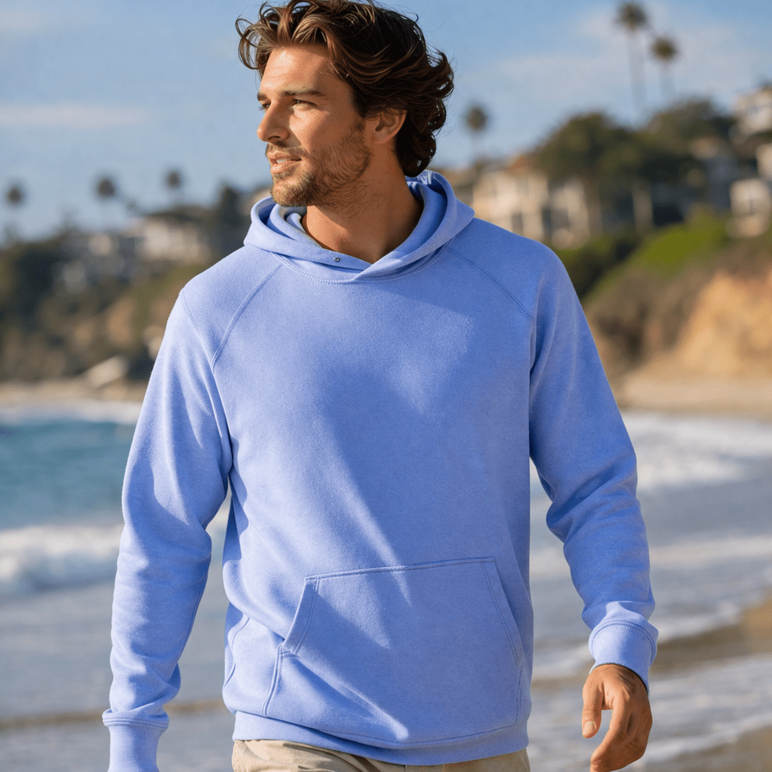 Man wearing a light blue hoodie on a beach