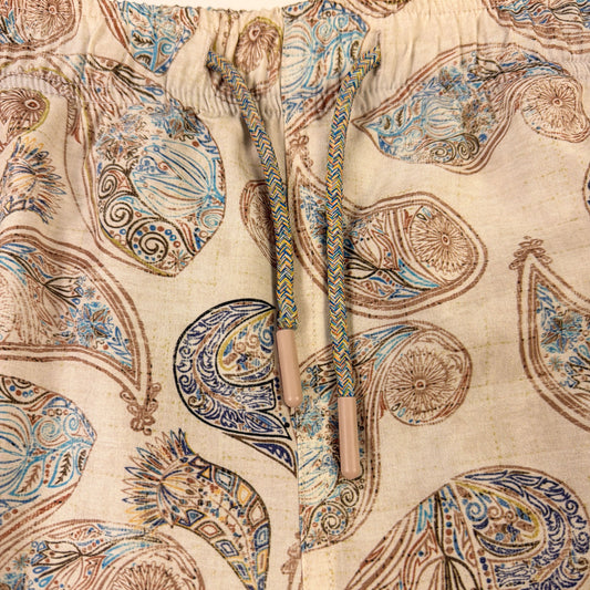 Close-up of a fabric with intricate paisley pattern on a beige background