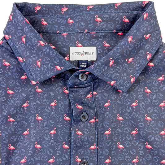 Folded navy blue polo shirt with pink flamingo pattern on a light gray background