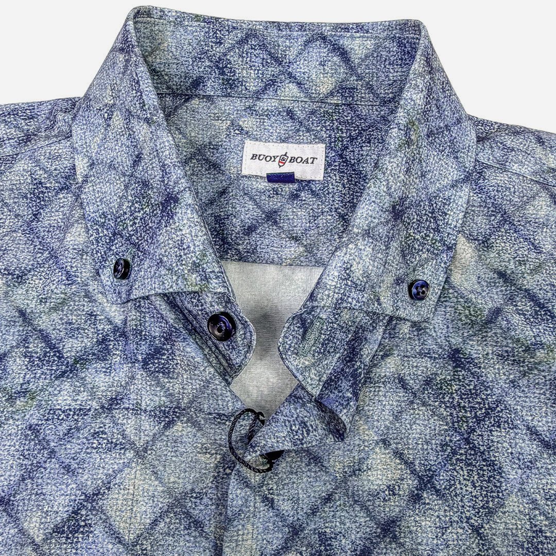 Blue patterned shirt with a visible brand label on a white background